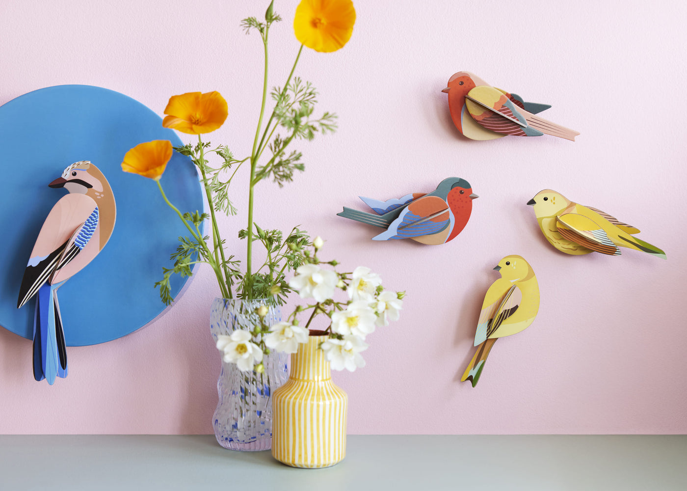 Birds chirp around us, pecking at some crumbs, glancing around, then fluttering away. They add color to our daily lives.